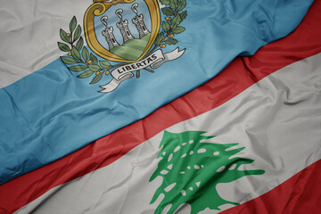 waving colorful flag of lebanon and national flag of san marino.