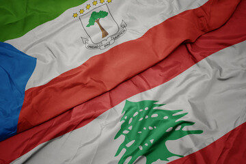 waving colorful flag of lebanon and national flag of equatorial guinea.