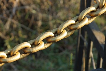 long of a big yellow iron chain in a fence outside