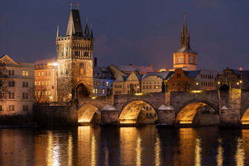 Fototapeta na wymiar .Charles Bridge on the Vltava River and statues on the bridge and light from the street lights and a fallen dream in winter in the early evening in the center of Prague