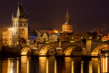 Fototapeta na wymiar .Charles Bridge on the Vltava River and statues on the bridge and light from the street lights and a fallen dream in winter in the early evening in the center of Prague