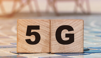 5G letters on wood blocks on swimming pool borders and beach. Big data concept