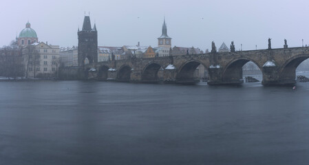 Obraz premium .Charles Bridge on the Vltava River and statues on the bridge and light from the street lights and a fallen dream in winter in the early evening in the center of Prague