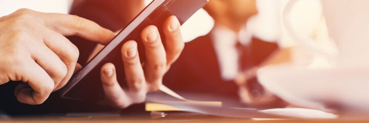 Hand using smart phone in business meeting, close up. Banner frame.