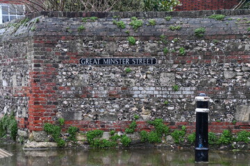 Street sign on the old brick wall in Winchester, England, Great Britain