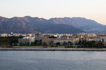 Fototapeta na wymiar evocative image of the view of the city of Palermo from a ferry with the mountains in the background at sunset 