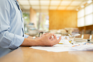 Close up calm businessman is meditating in office. businessman is exercising lotus pose yoga for relax during work
