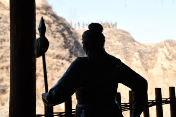 Silhouette of bronze statue in the balcone of the fortress, China
