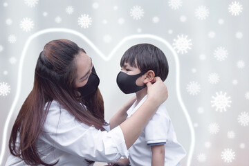 Mother puts on protective cotton mask to her son in the garden, protect COVID-19, Coronavirus concept.