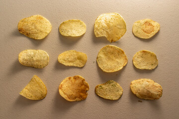 Potato Chips (Crisps) with basil located grid like order pattern on white table.