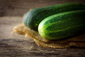 Fresh cucumber on rustic wooden background.