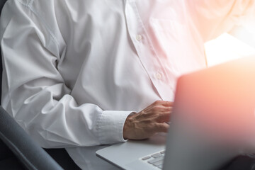 Business man hard working concept. Back of businessman work on multichannel devices notebook laptop computer and smartphone at night using 5g and wireless wifi network from home