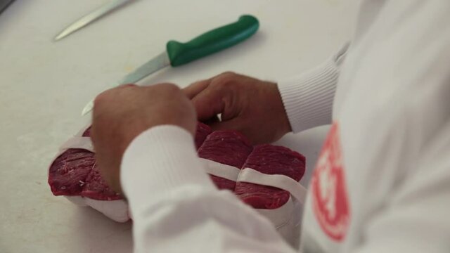 Bardage et le ficelage d'un rosbif coup&eacute; dans l'aiguillette de rumsteak. 