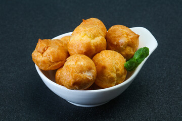 Sweet tasty profiteroles heap in the bowl