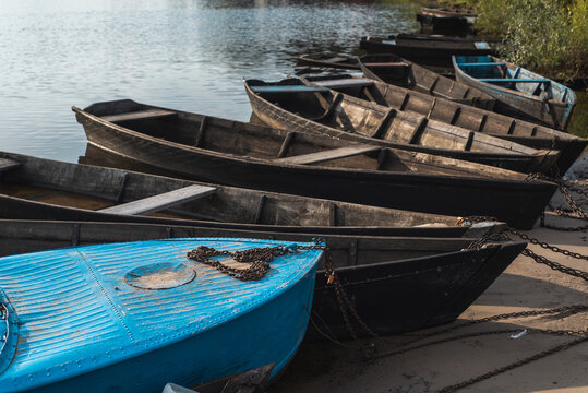 Wooden authentic old boats on the river bank. Life in the village of ordinary people. Transport and fishing vehicle.