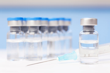 Vials and syringe with vaccine against covid-19