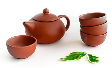 Terracotta teapot and cups on white background