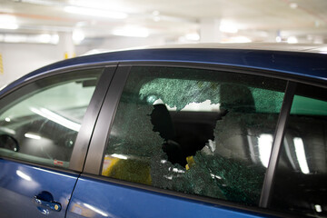 Broken car glass window from thief. Car robbery in garage parking. 
