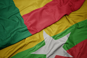 waving colorful flag of myanmar and national flag of benin.