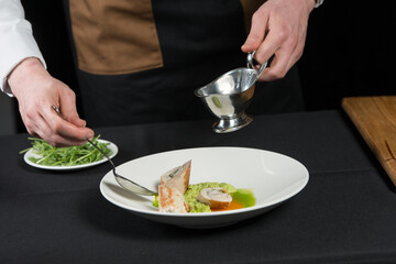 The chef prepares a serving of meatloaf. Pour the sauce over the dish. black tablecloth