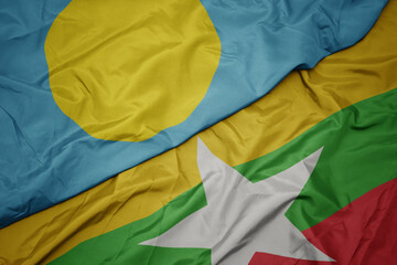waving colorful flag of myanmar and national flag of Palau .