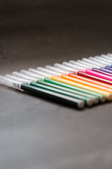 Naklejka premium Colorful markers on a dark background. Concept of education, learning, creative and arts and crafts.