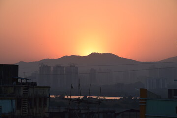 the sun sets through the city