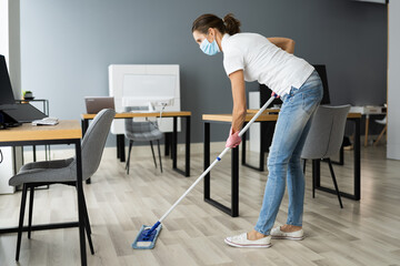 Female Janitor Mopping Floor In Face Mask