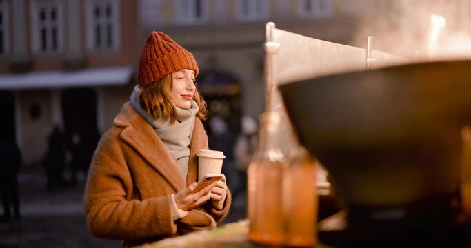 Woman buying street food at Christmas market on a winter holidays at night. Handheld video shot