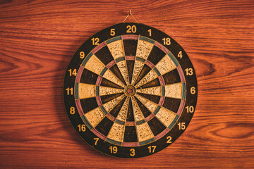 A dartboard hanging on a wallpapered wall