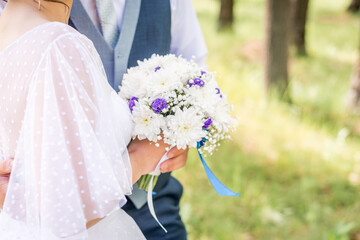 bride and groom holding beautiful wedding bouquet of flowers