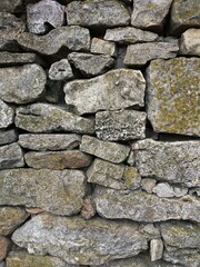 old grey wall of natural different size stones 