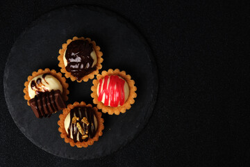 Flatlay picture of 4 type homemade cheese tart on slate plate.