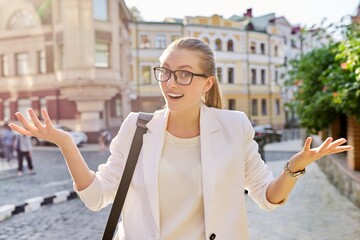 Outdoor portrait of young business positive woman in the city