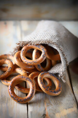 Bagels with poppy seeds in a bag on a wooden surface. Fresh bagels with poppy seeds.