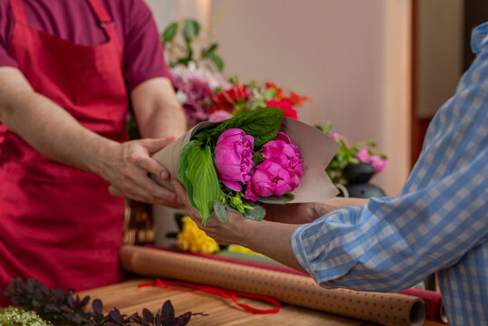 Crop view saller of flowers. Floristic business. Arrangement of bouquets.