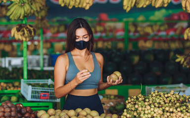 Young girl in a mask in a fruit store