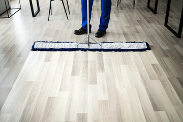 Male Janitor Mopping Floor In Face Mask