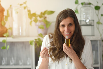 Woman with open Serum-elixir bottle enjoying its aroma