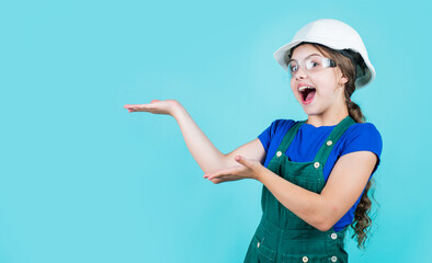 kid work in the helmet. little girl in a helmet. girl making repairs. teen dressed in hard hat. childhood development. girl in helmet is construction worker. foreman teen child. presenting product