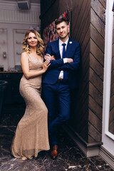 Photoshoot of the bride and groom in the studio. Beige dress and blue suit.