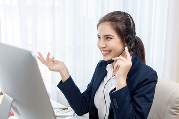 Portrait of happy smiling female call center operator working on computer in office.