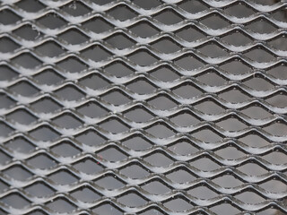 Texture in the form of rhombuses. Black metal mesh.