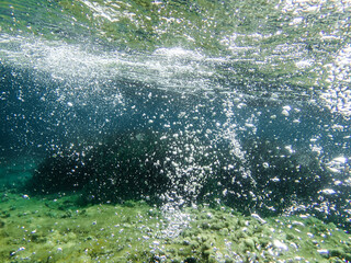 Bubbles under the sea in the crystal clear green sea water. Mediterranean bubbles. Real image very suitable for backgrounds