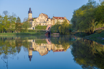 Fototapeta premium View of the Nesvizh Castle from the side of the Castle Pond on a sunny May morning. Belarus