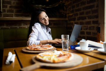 Young businesswoman Communicates with business partners using a laptop and telephone