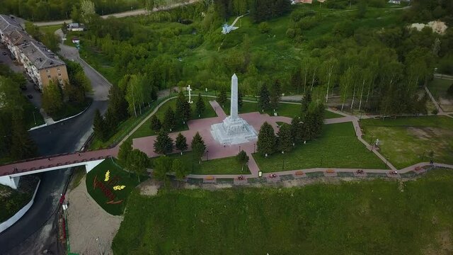 The tall obelisk monument stands on a hill in a small town. Quadrotor filming