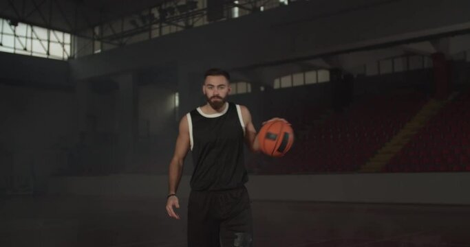 Video portrait of a basketball player bouncing a ball. Caucasian man in uniform posing inside sports hall