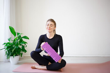 young beautiful woman hold in her hands massage roller