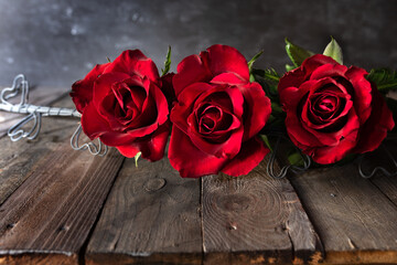 Red roses on dark wooden boards. Background for valentine's day greeting card with space for text....